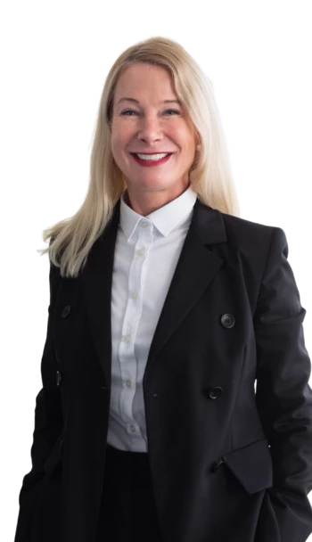 Eine weibliche Führungskraft mit Blazer und Bluse. Sie lächelt freundlich in die Kamera.